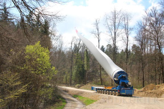 Ein Rotorblatt steht im Walde: Der Flügel auf einer selbst fahrenden Lastzugmaschine wird kurzzeitig parkiert. | Bild: Albert Bittlingmaier